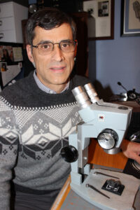 Dr. John Jaszczak working next to a microscope