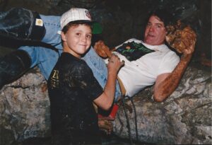 Bill and Will Larson shown inside a mine, holding specimens they dug.
